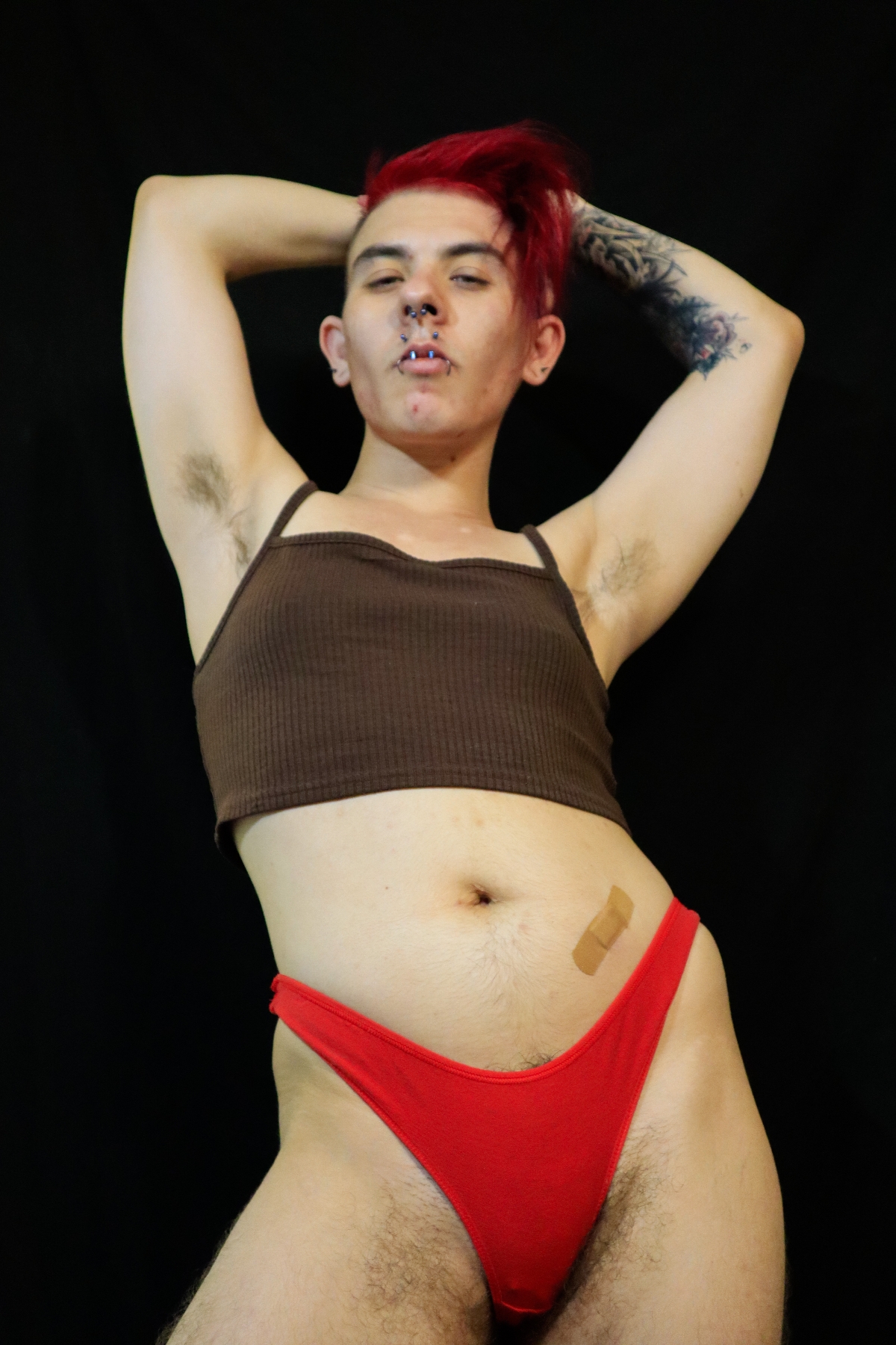 Wearing a red thong and a brown crop top